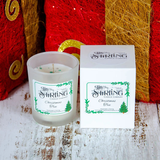 Christmas Tree scented small candle by The Stirling Candle Company with matching box, on a wooden surface.