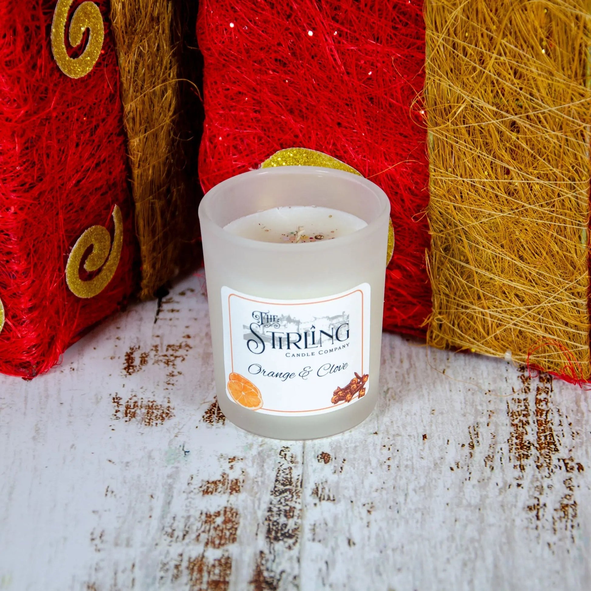 Small Orange & Clove candle, hand-poured in Stirling, Scotland with sustainable wax, against festive background.