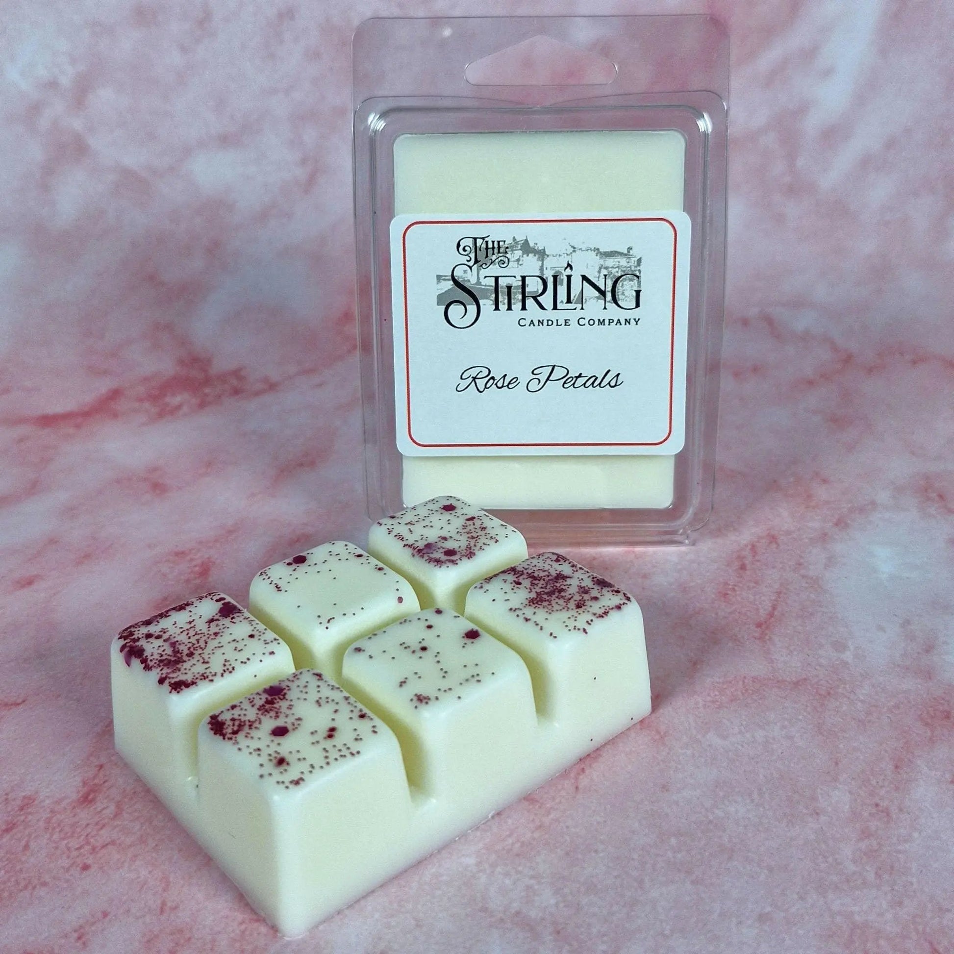 Rose Petals wax melt clamshell with a 6-cube bar, showing a white wax melt sprinkled with red petals, on a pink background.