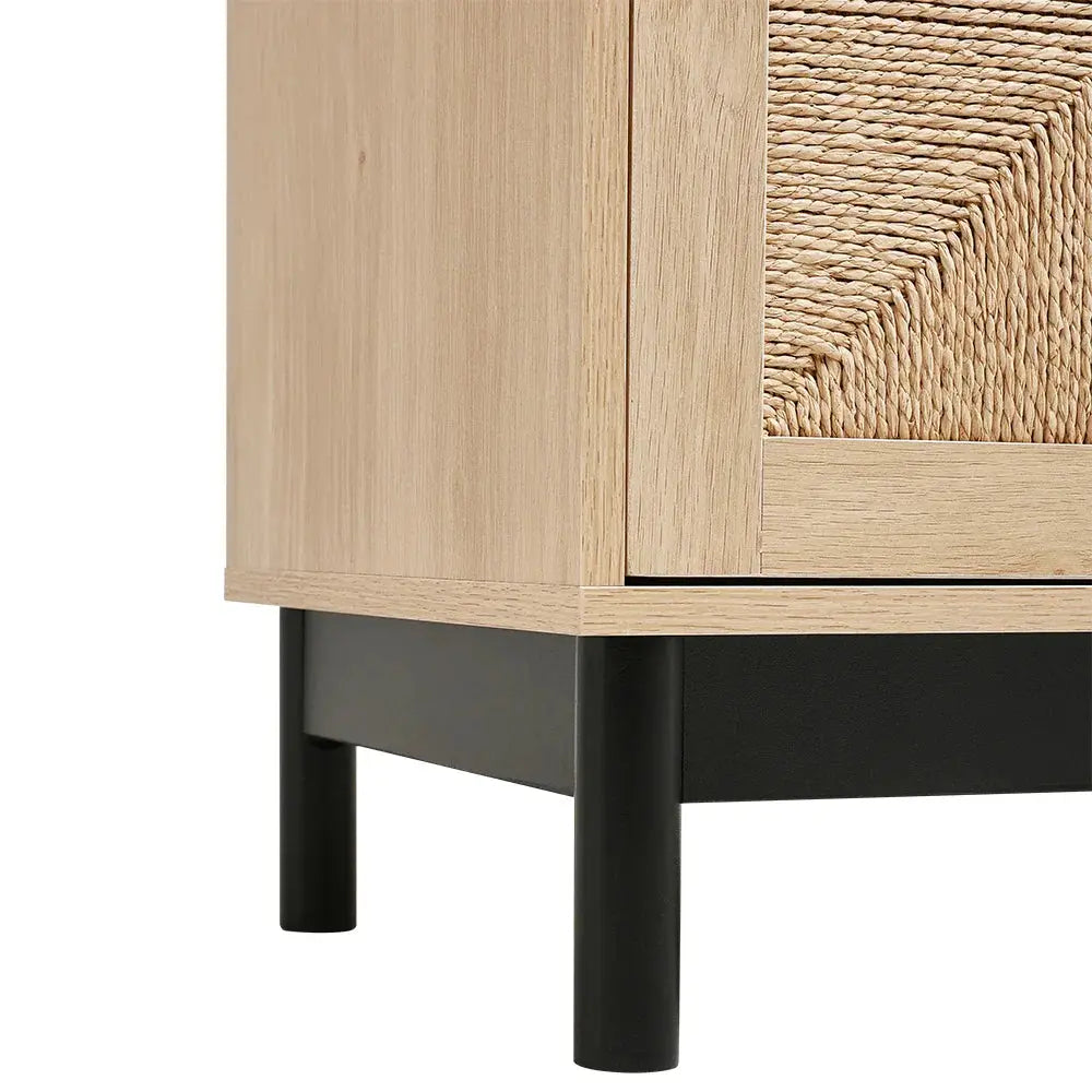 Close-up of wooden sideboard showing rattan woven door texture and black metal base with legs.