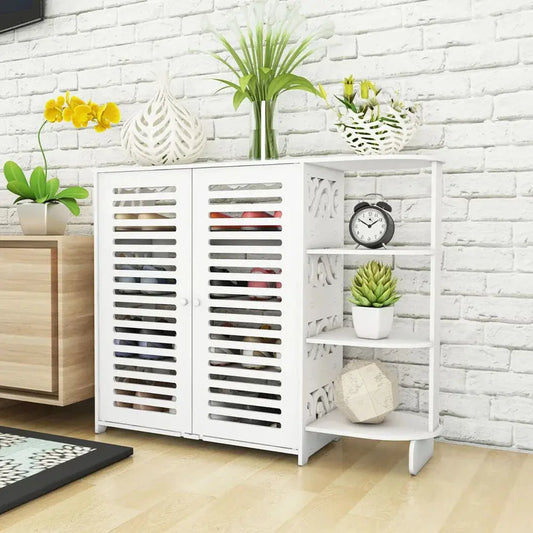 White double door 4-layer shoe cabinet with open shelves, next to a wooden cabinet, against a white brick wall