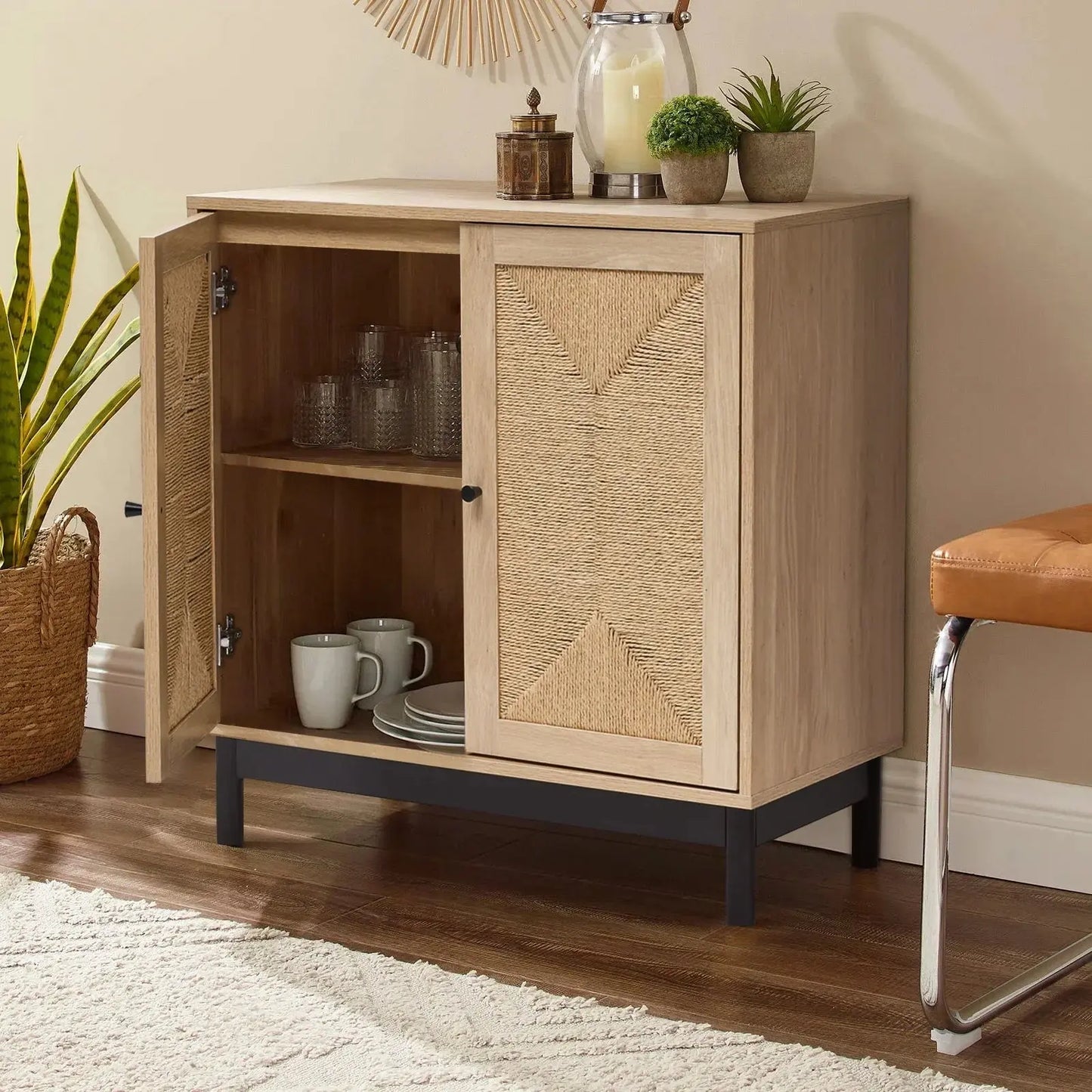 Rattan double door wooden sideboard with one door open, revealing glasses and plates on shelves. Black metal base.