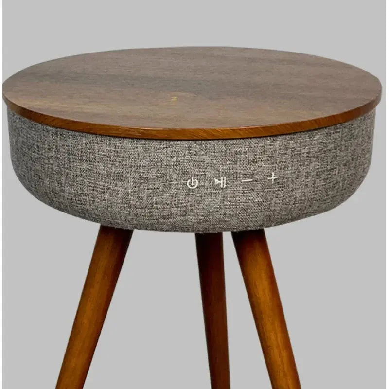Round wooden smart coffee table with grey fabric sides and control buttons for music and power.
