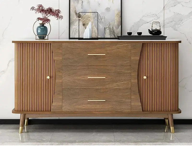 Modern minimalist wooden showcase cabinet with fluted doors, three central drawers, and golden pulls in a living room.