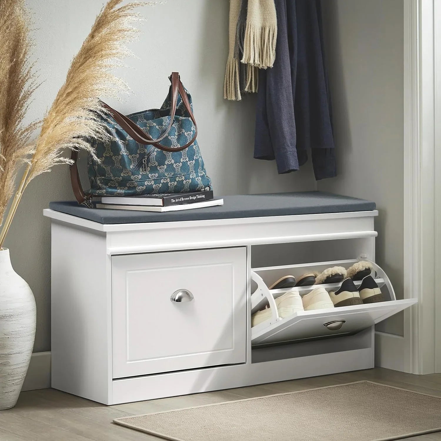 White flip-top shoe cabinet bench with grey cushion, open shoe rack, and storage drawer in entryway.