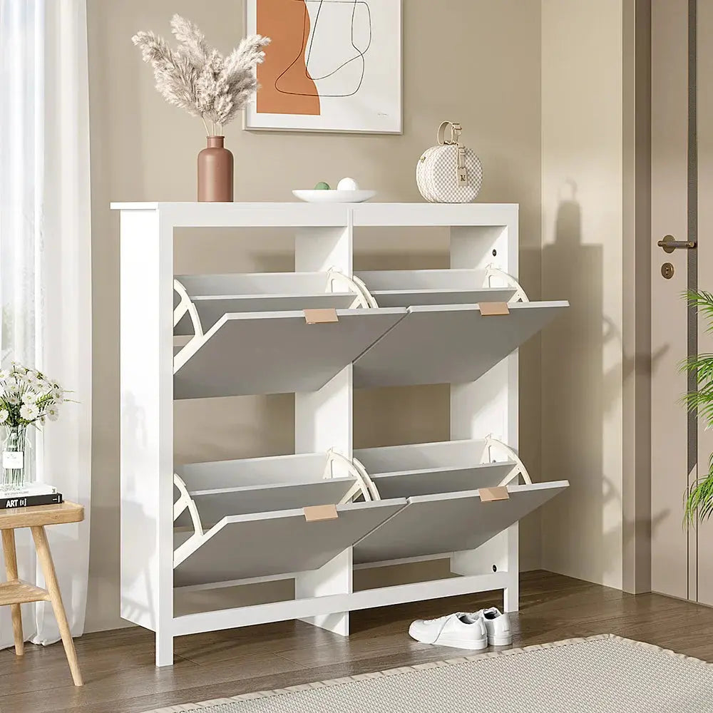 White flip-down wood shoe cabinet with 4 grey shelves open, in a hallway with decor.