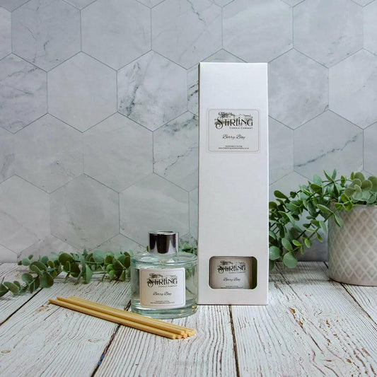 Berry Bay 100ml floral reed diffuser in glass bottle with reeds and white box on wood table