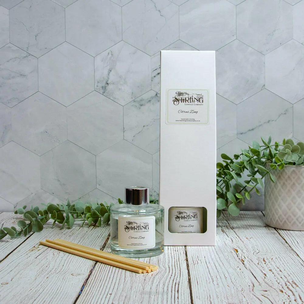 Citrus Zing 100ml diffuser bottle with reeds, next to its white packaging box, against a patterned wall.
