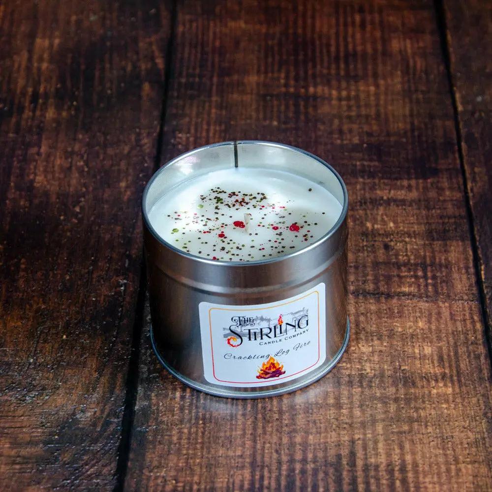 Crackling Log Fire Travel Tin Candle, open with visible cotton wick & festive sprinkles.