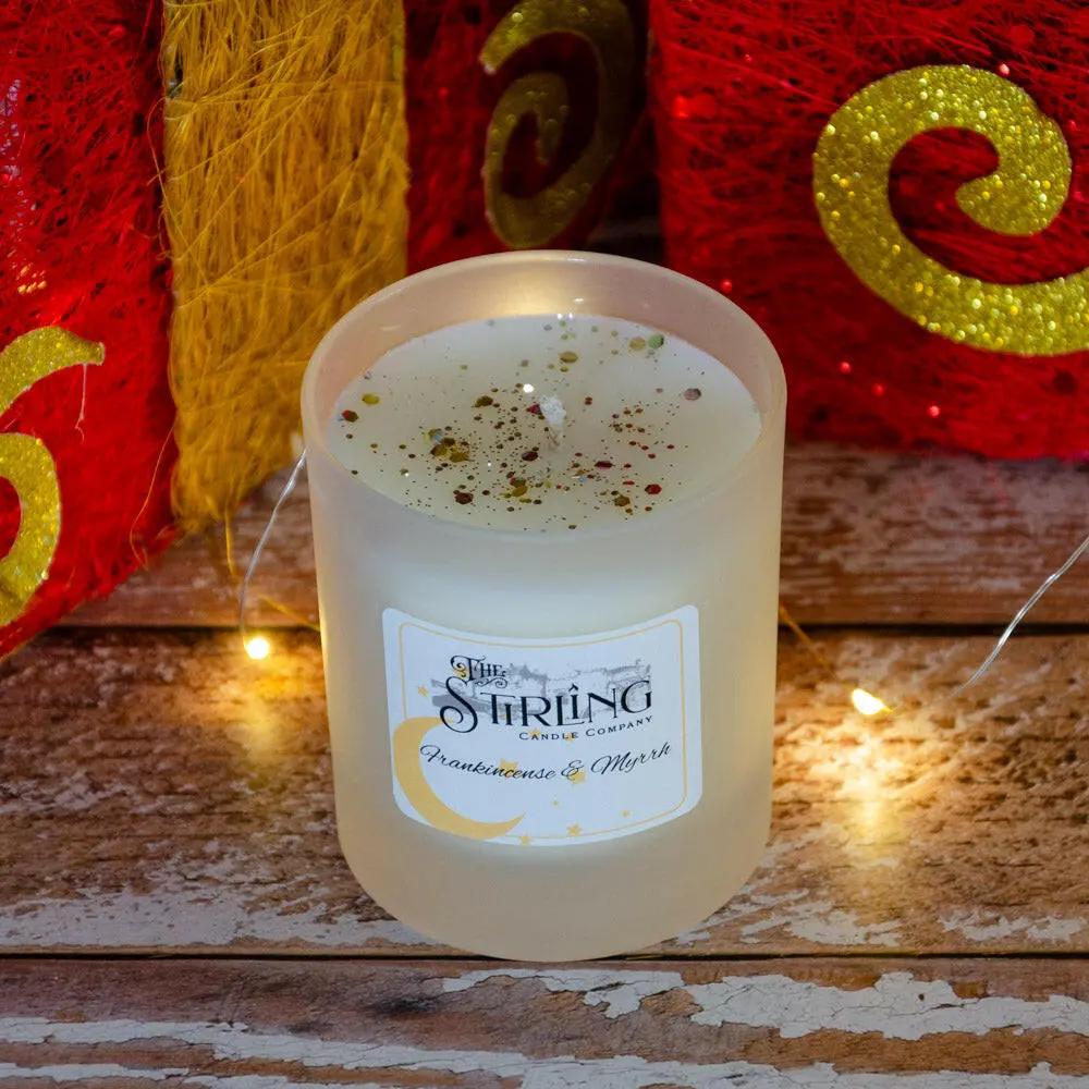 Frankincense & Myrrh medium candle in a frosted glass jar with glitter, showing label with The Stirling Candle Company logo