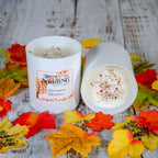 Two Autumn Nights large candles, white with autumn-themed labels, on a rustic wooden background with fall leaves.