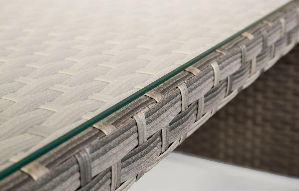 Close-up of Palma grey rattan garden dining table with glass top and woven texture