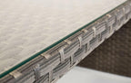 Close-up of Palma grey rattan garden dining table with glass top and woven texture