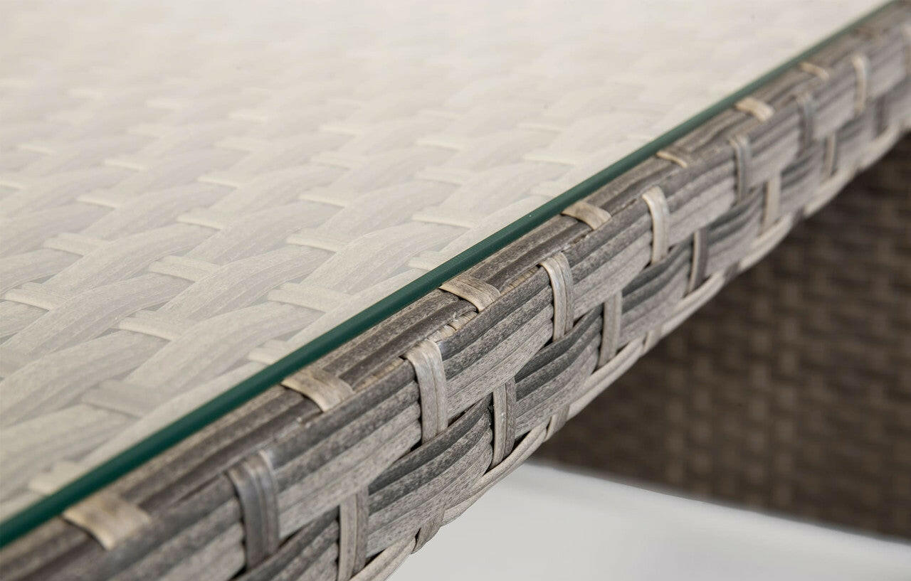 Close-up of Palma grey rattan garden dining table with glass top and woven texture