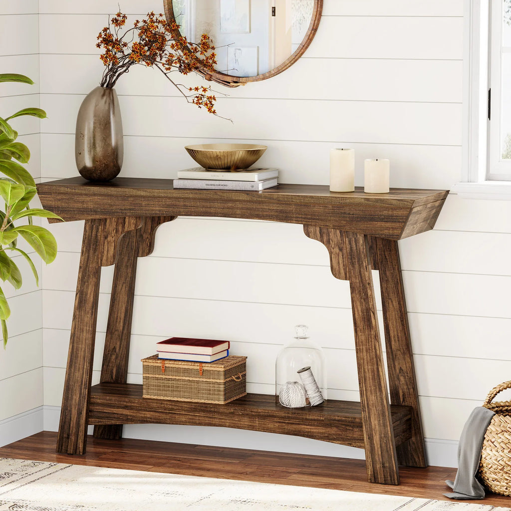 Rustic brown 2-tier entryway table with decorative vase, books, and candles in a living room.