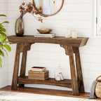 Rustic brown 2-tier entryway table with decorative vase, books, and candles in a living room.