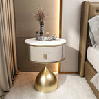 Luxury Unique Gold Nightstand with white marble top, round drawer, and golden conical base, beside a bed.