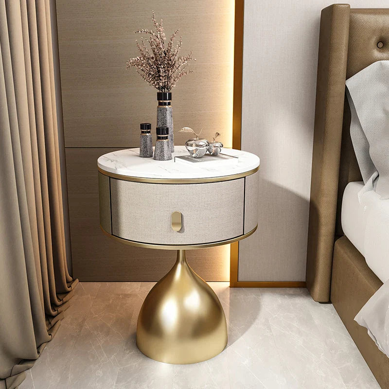 Luxury Unique Gold Nightstand with white marble top, round drawer, and golden conical base, beside a bed.
