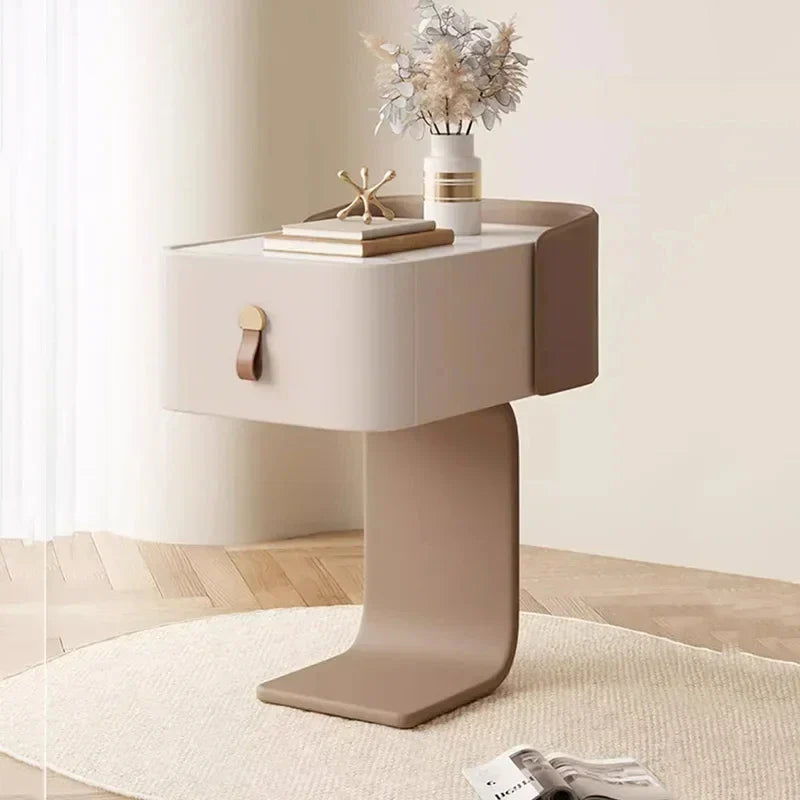 Japanese minimalist nightstand with one drawer, leather pull, and curved base, styled with a vase and books.