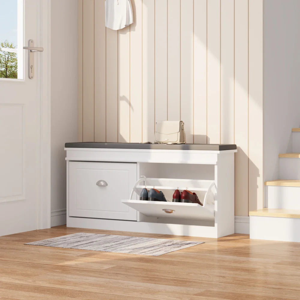 White flip-top shoe cabinet with silver handles, open compartment revealing shoes, in an entryway with a rug