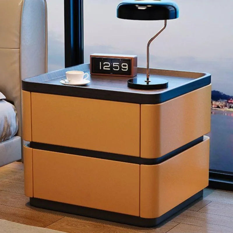 Minimalist premium bedside cabinet with two camel nappa leather drawers, dark wood top, modern lamp, and alarm clock.