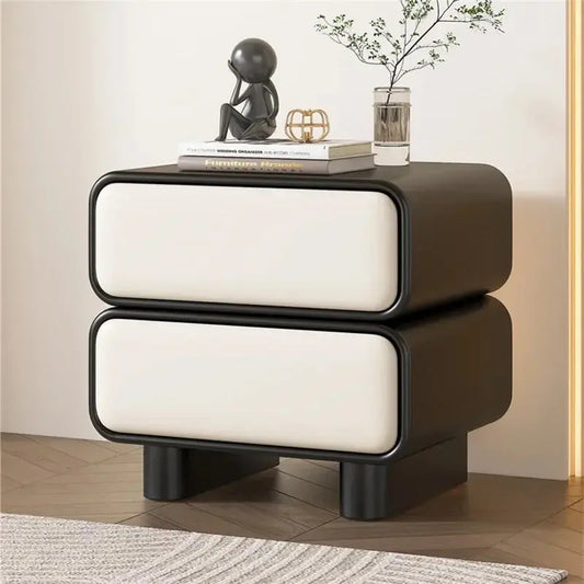 Modern Moroccan bedside table with two white drawers, black frame, and short black legs, shown in a bedroom.