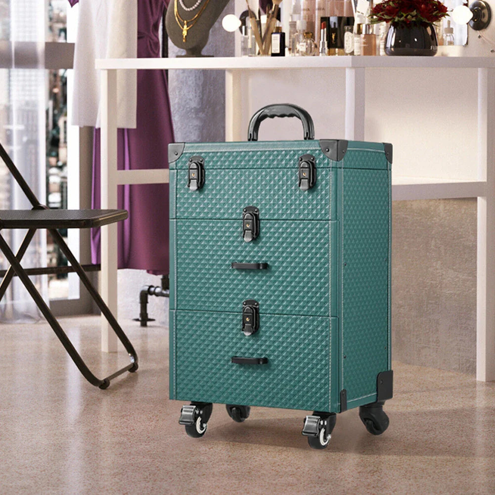 Green professional rolling makeup case with multiple layers, drawers, and wheels, on a floor in a room setting.