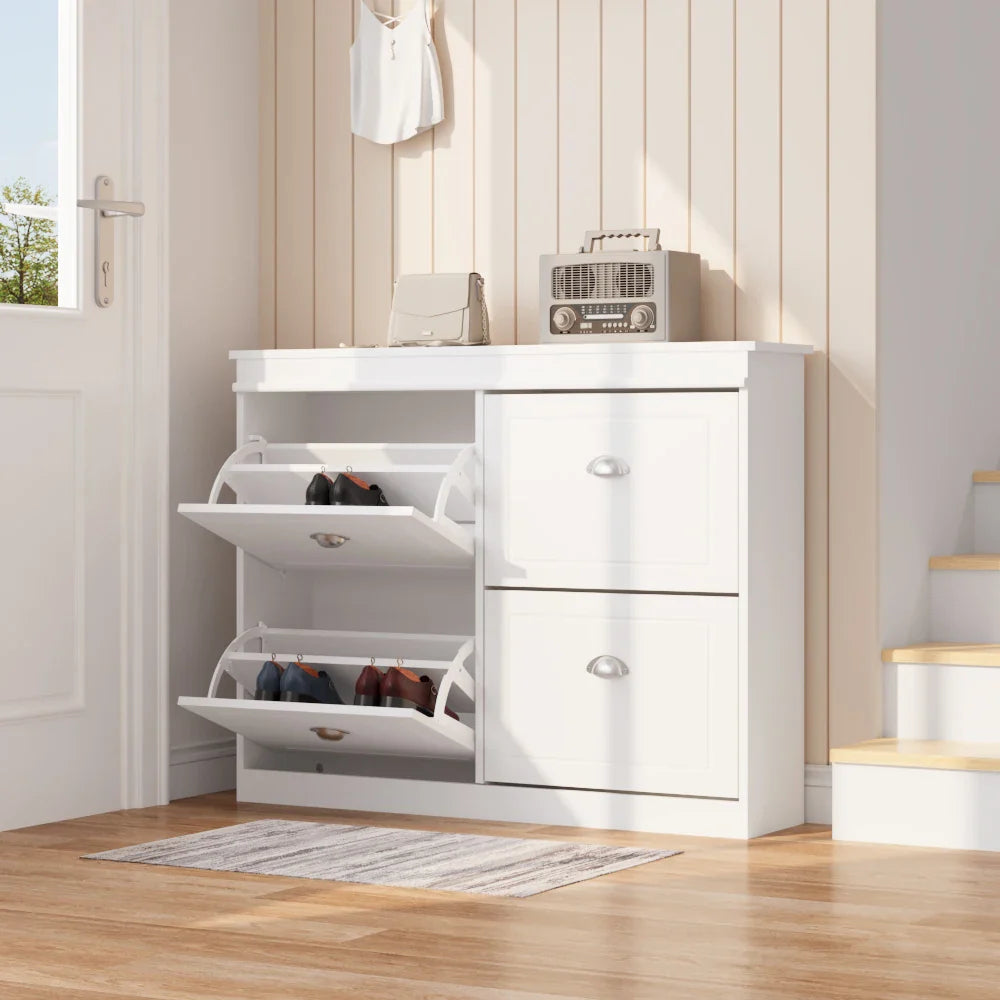 White flip-top shoe cabinet in an entryway, with two compartments open displaying shoes. Modern shoe organizer with drawers.
