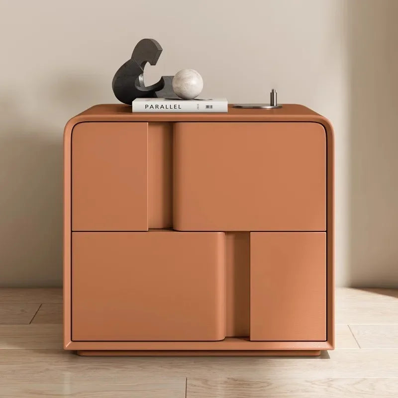Modern orange double-layer storage bedside table with smooth rounded edges, styled with a book and decor items.