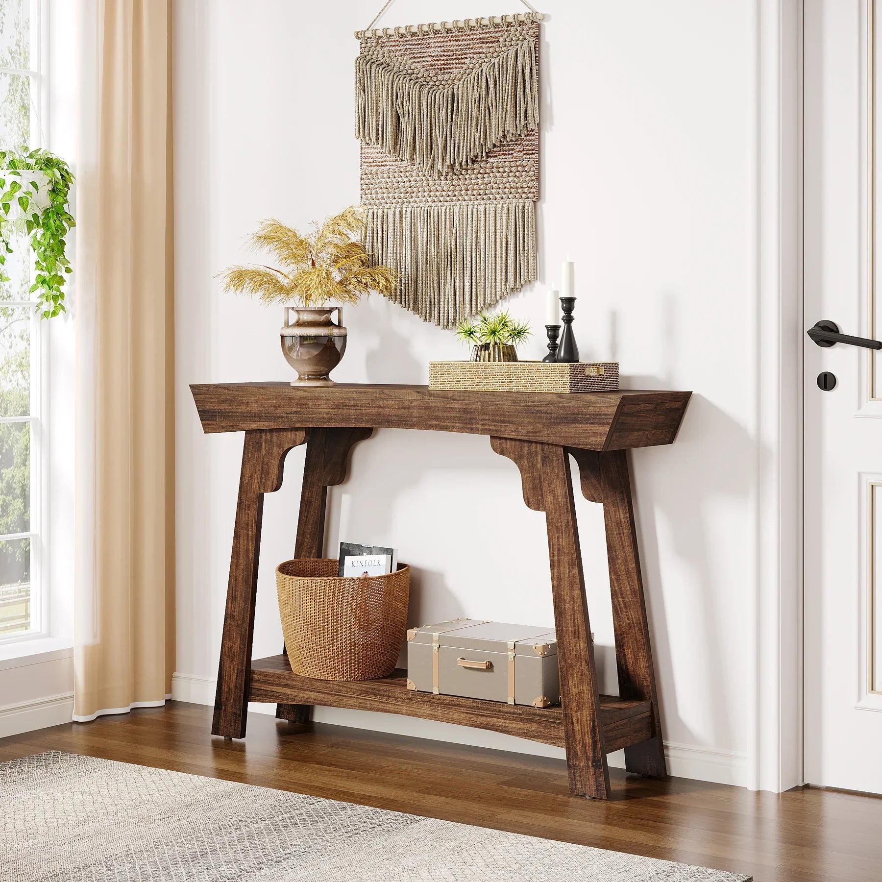 Rustic brown 2-tier entryway table with storage in a cosy hallway, decorated with a vase, candles, and woven baskets
