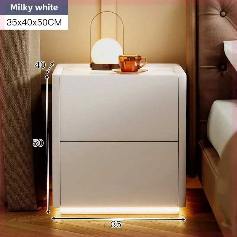 Milky white modern rustic nightstand with two drawers, 35x40x50CM, beside a bed with a lamp and cup.