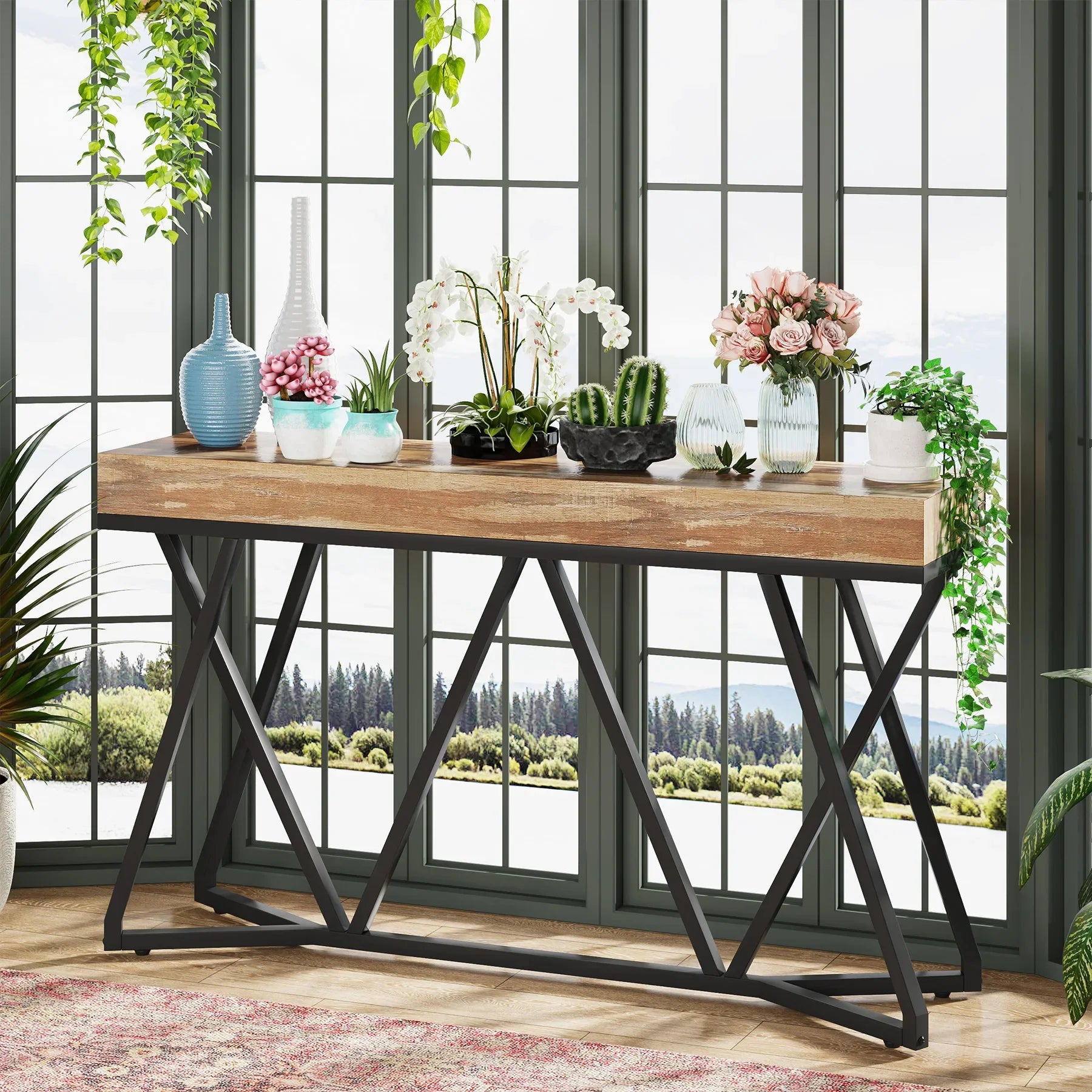 55 inch industrial console table with wood-effect top and black metal base in a living room with plants