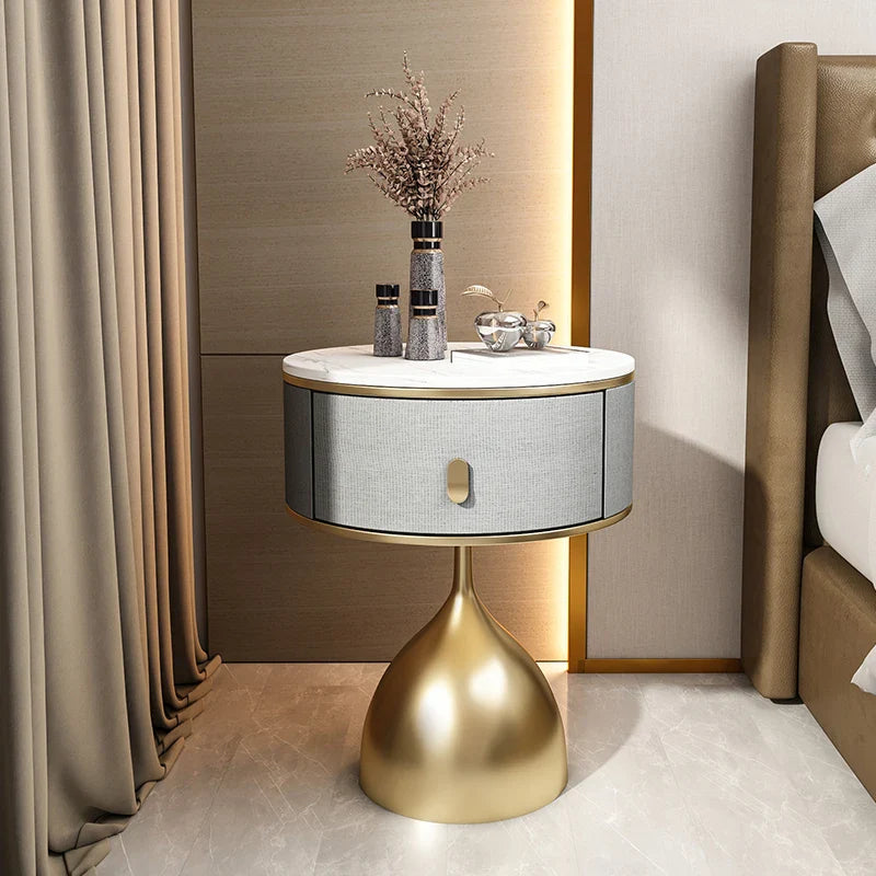 Luxury unique gold nightstand with white marble top, grey fabric drawer, and golden pedestal base.
