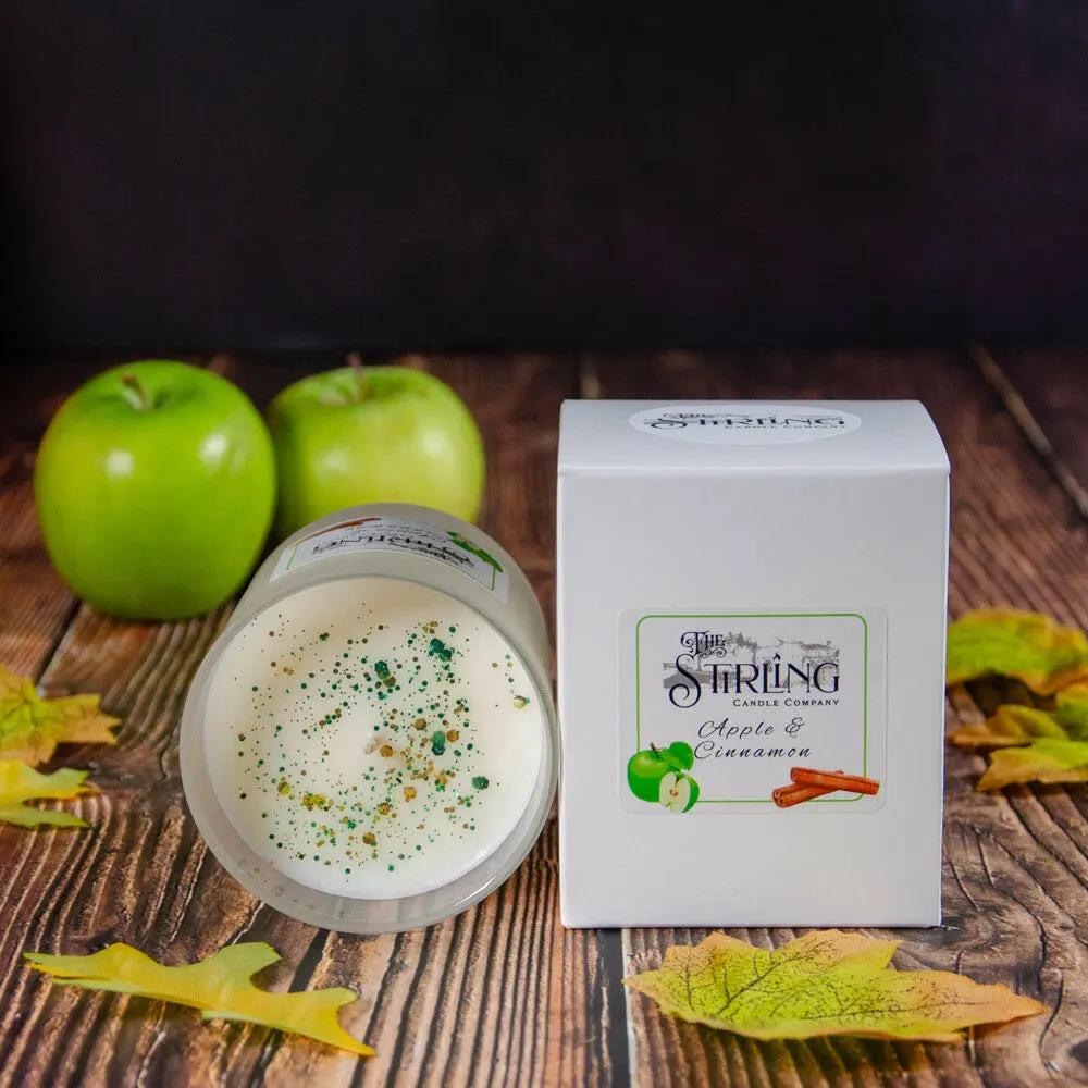 Apple & Cinnamon medium candle with box, green apples, and autumn leaves on a wooden surface.