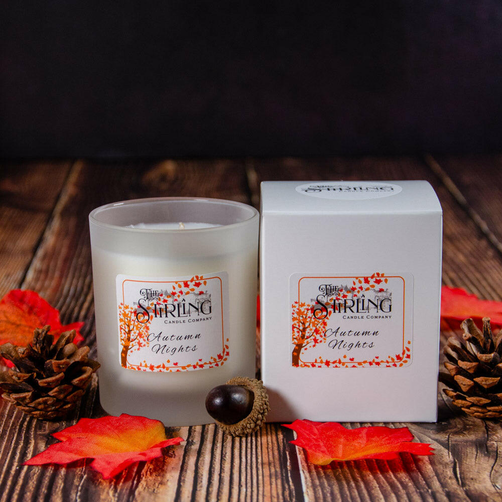 Autumn Nights Medium Candle by The Stirling Candle Company with matching packaging box, on a wooden surface.