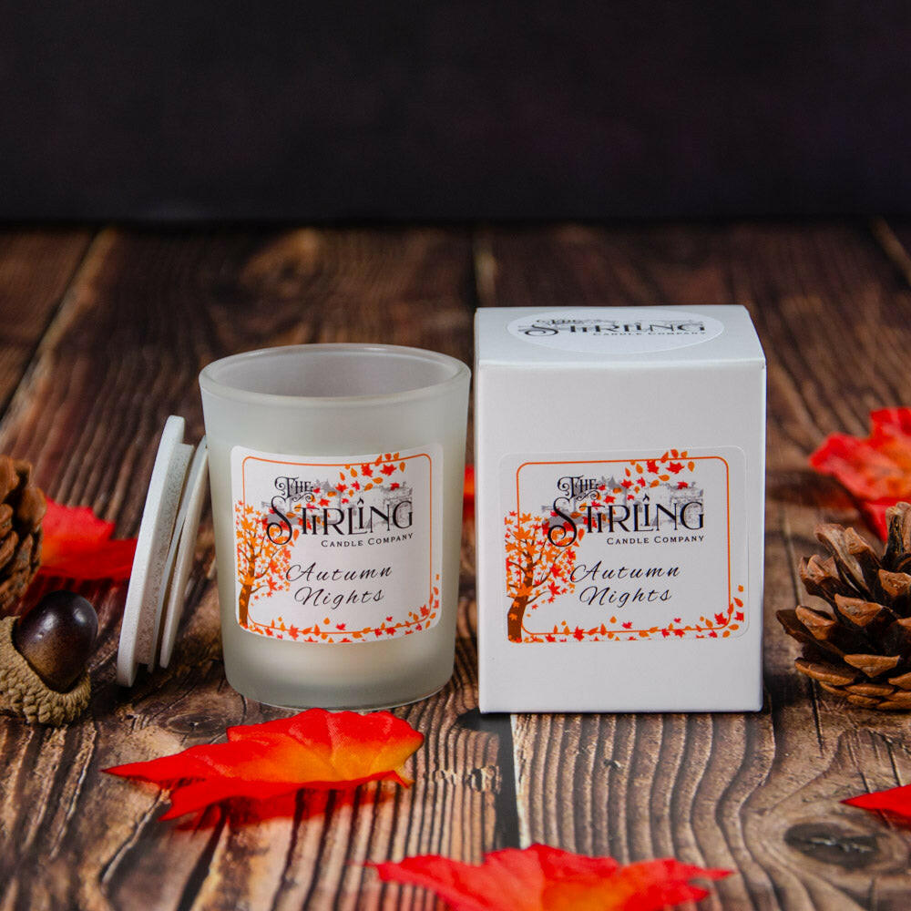 Autumn Nights small vegan candle, hand-poured in Scotland, with matching box on a wooden table with autumn leaves
