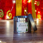 Christmas Tree travel tin candle with cotton wick, by Stirling Candle Company, lid slightly ajar, festive lights