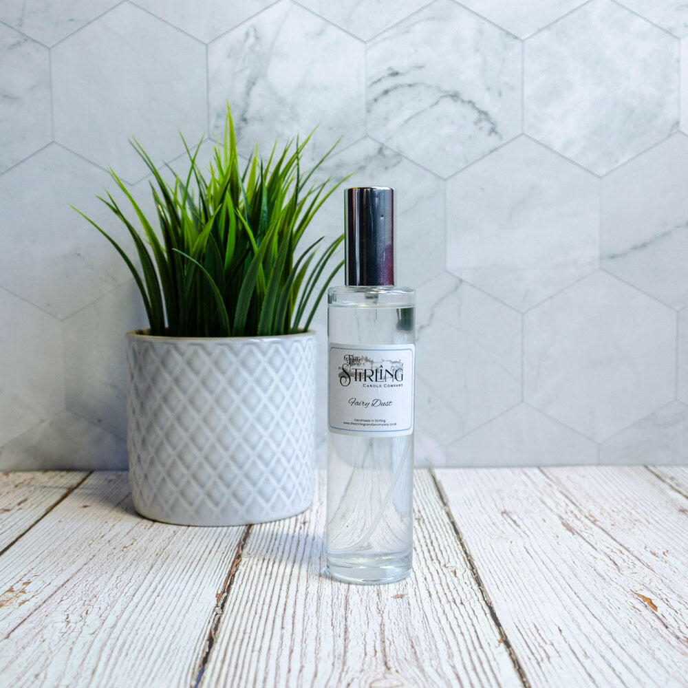 Fairy Dust 100ml room spray with bubble gummy scent, clear bottle next to a potted plant.